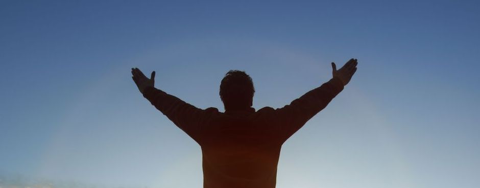 silhouette of a man raising his hands