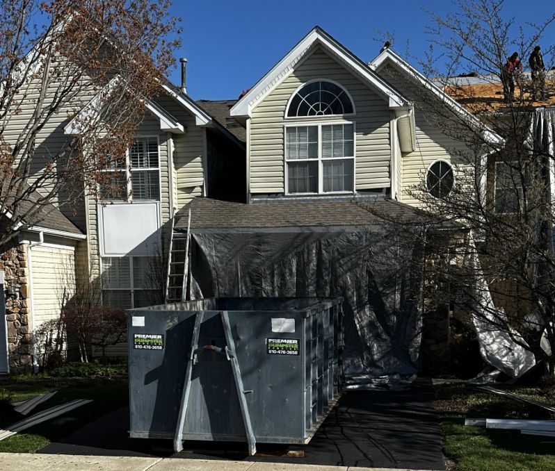 A large house with a dumpster in front of it