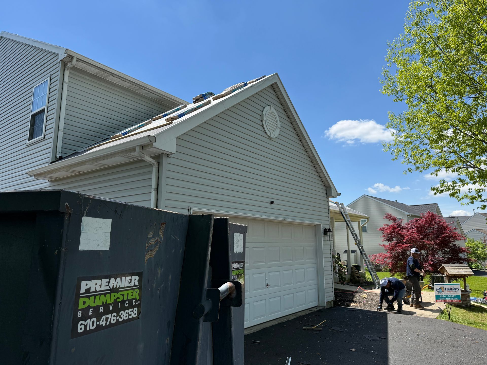 A group of people are working on the roof of a house