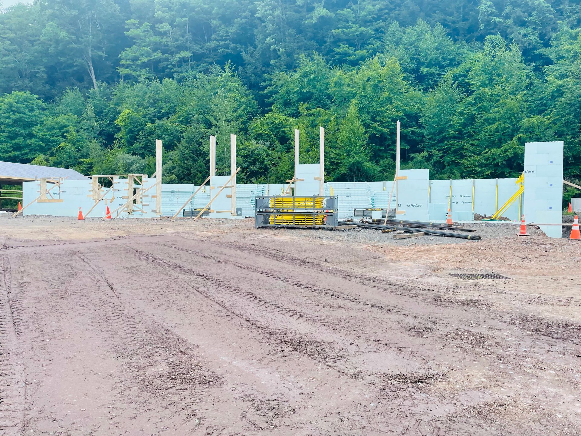 A construction site with a lot of dirt and trees in the background
