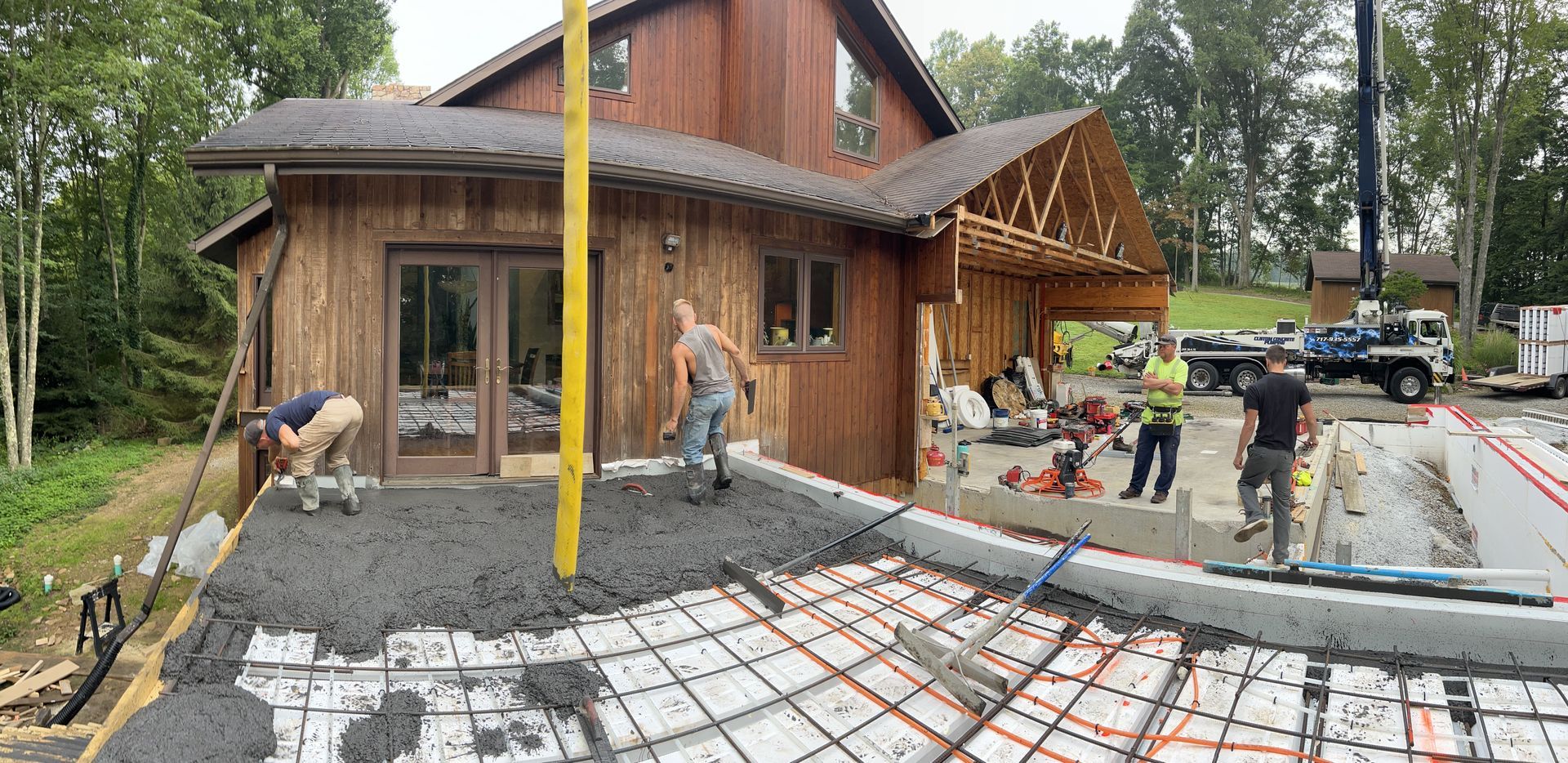 A large wooden house is being built with a lot of people working on it.