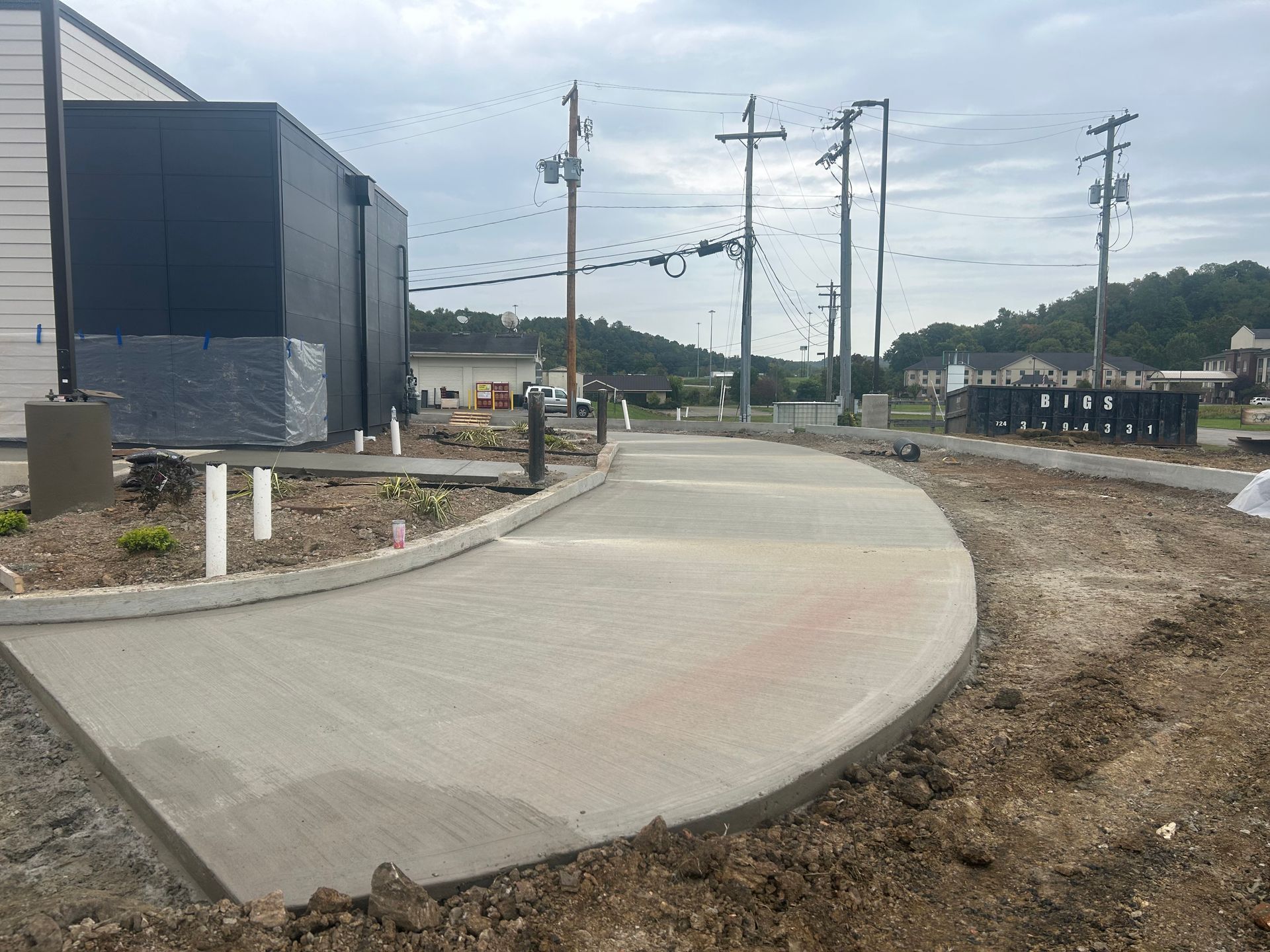 A concrete walkway is being built in front of a building.