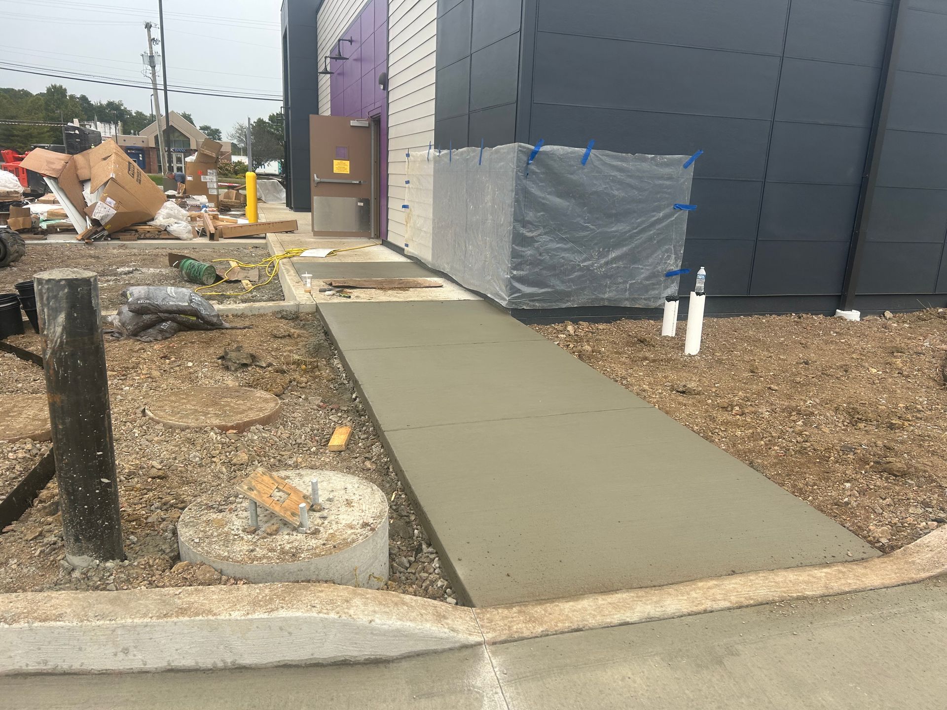 A concrete walkway is being built in front of a building.