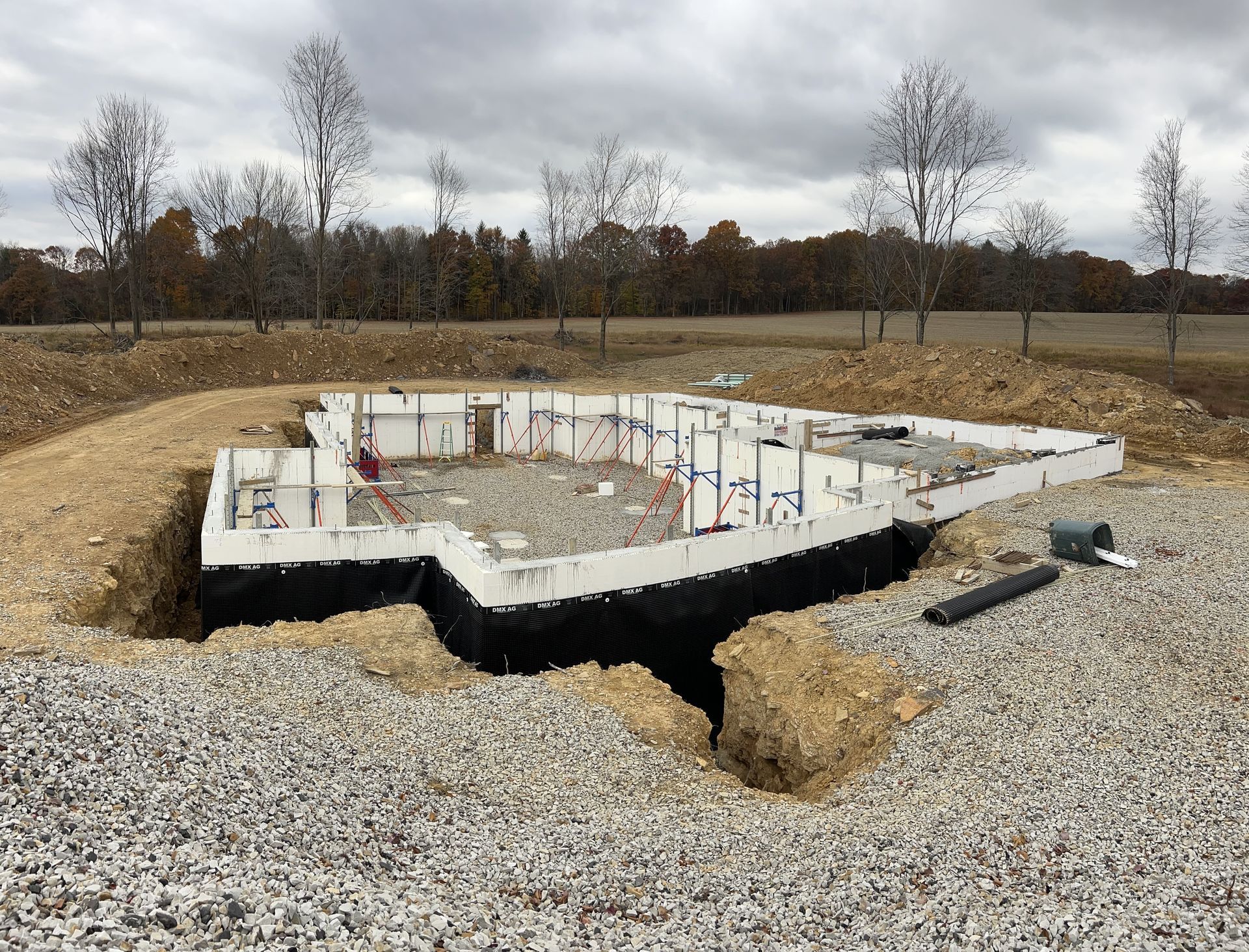 A foundation for a house is being built in a gravel area.
