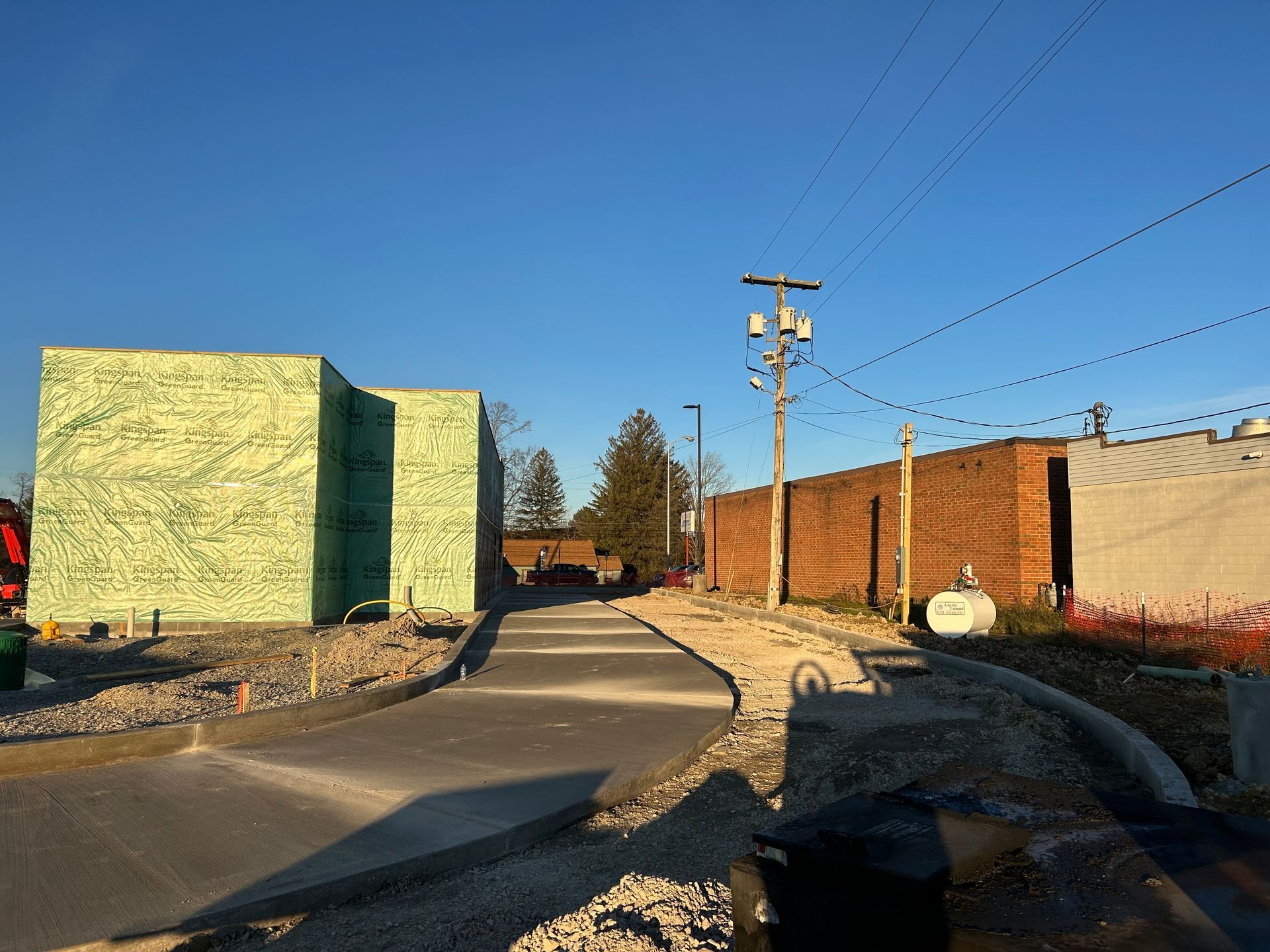A concrete walkway leading to a building under construction.