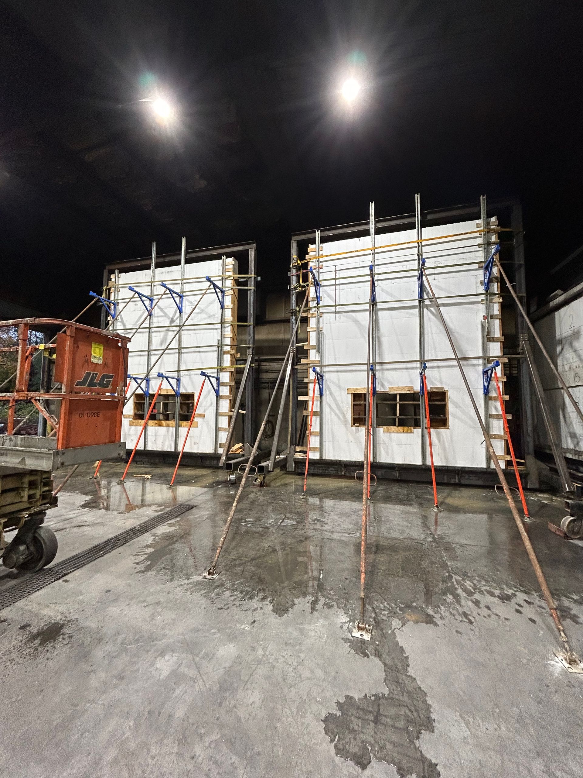 A construction site at night with scaffolding and a truck.