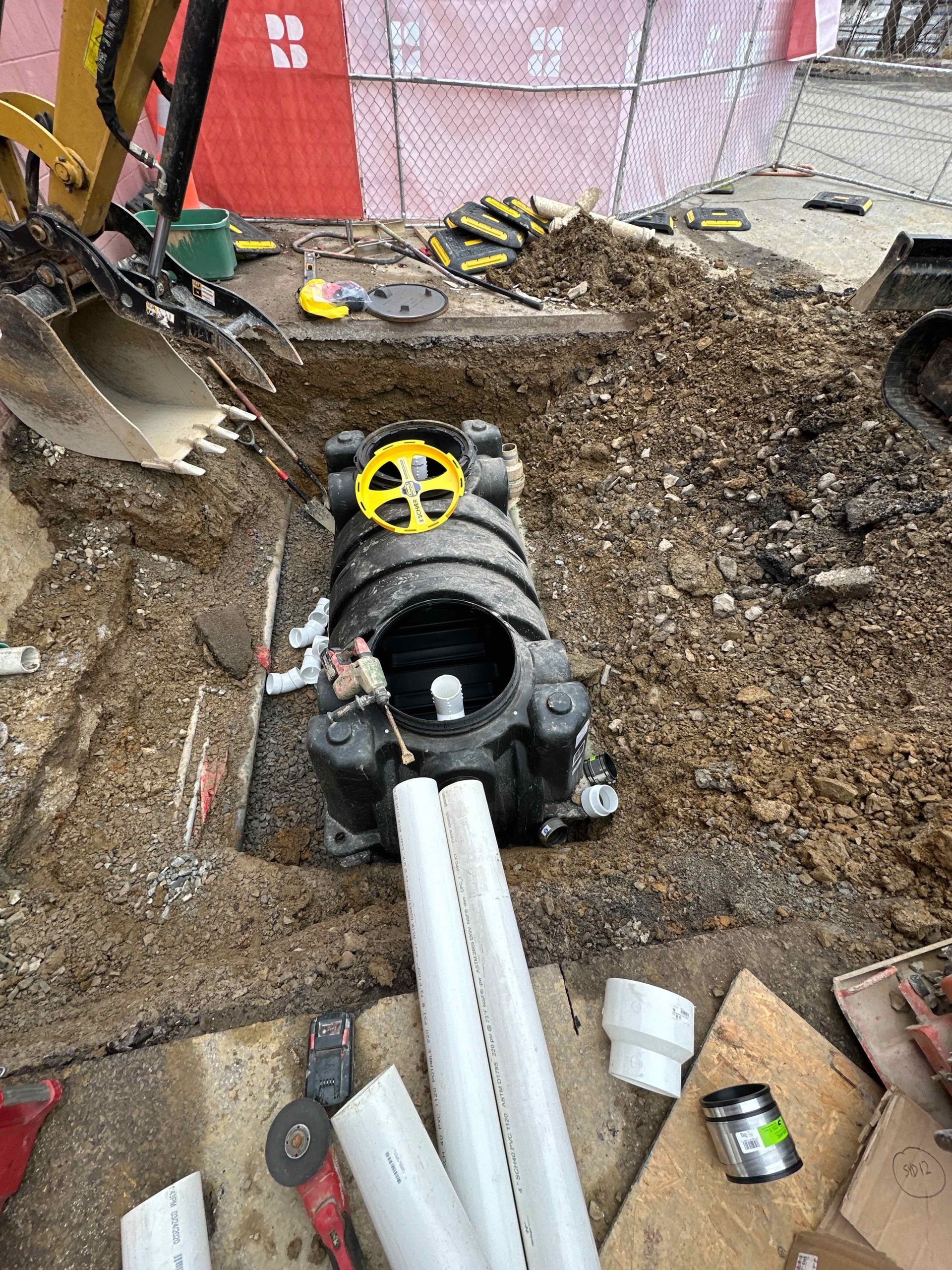 A pipe is being installed in a hole in the ground.