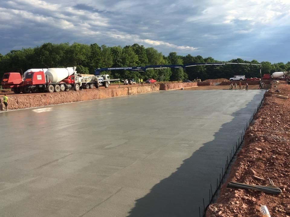 A concrete floor is being poured on a construction site.