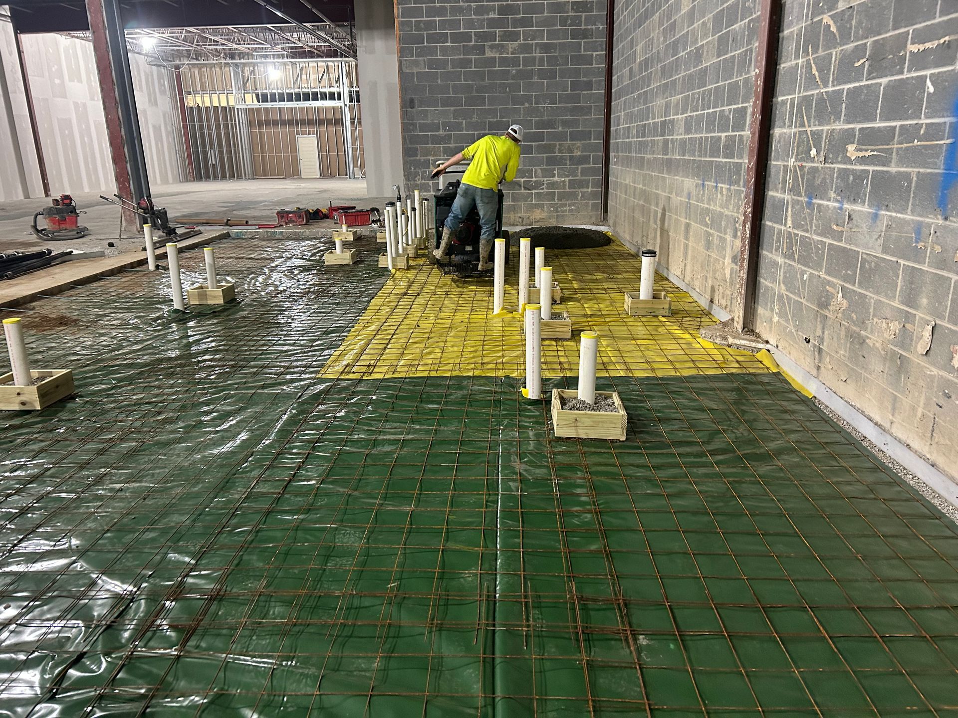 A man is working on a concrete floor in a building.
