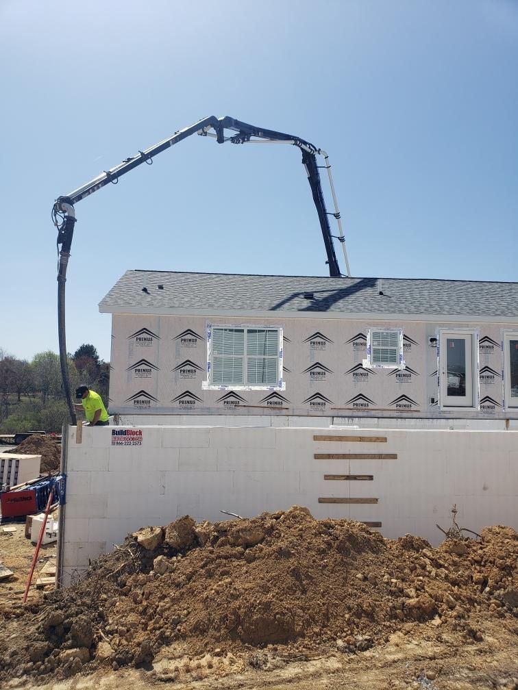 A concrete pump is being used to pour concrete into a house
