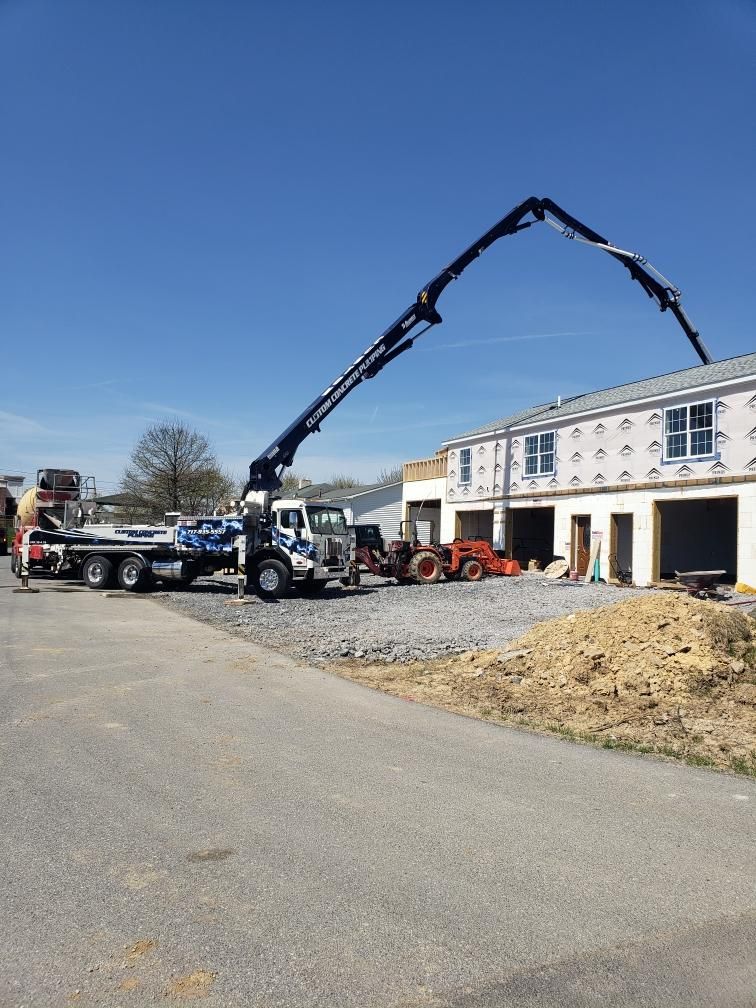 A concrete pump is being used to pour concrete into a building under construction.