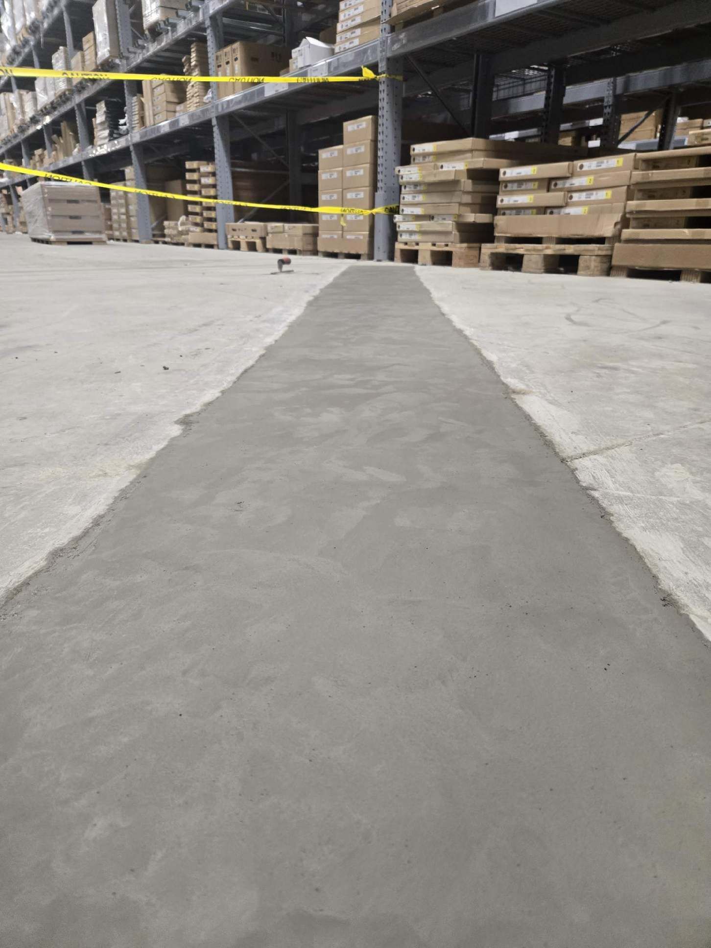 A warehouse with lots of shelves and boxes on the floor.