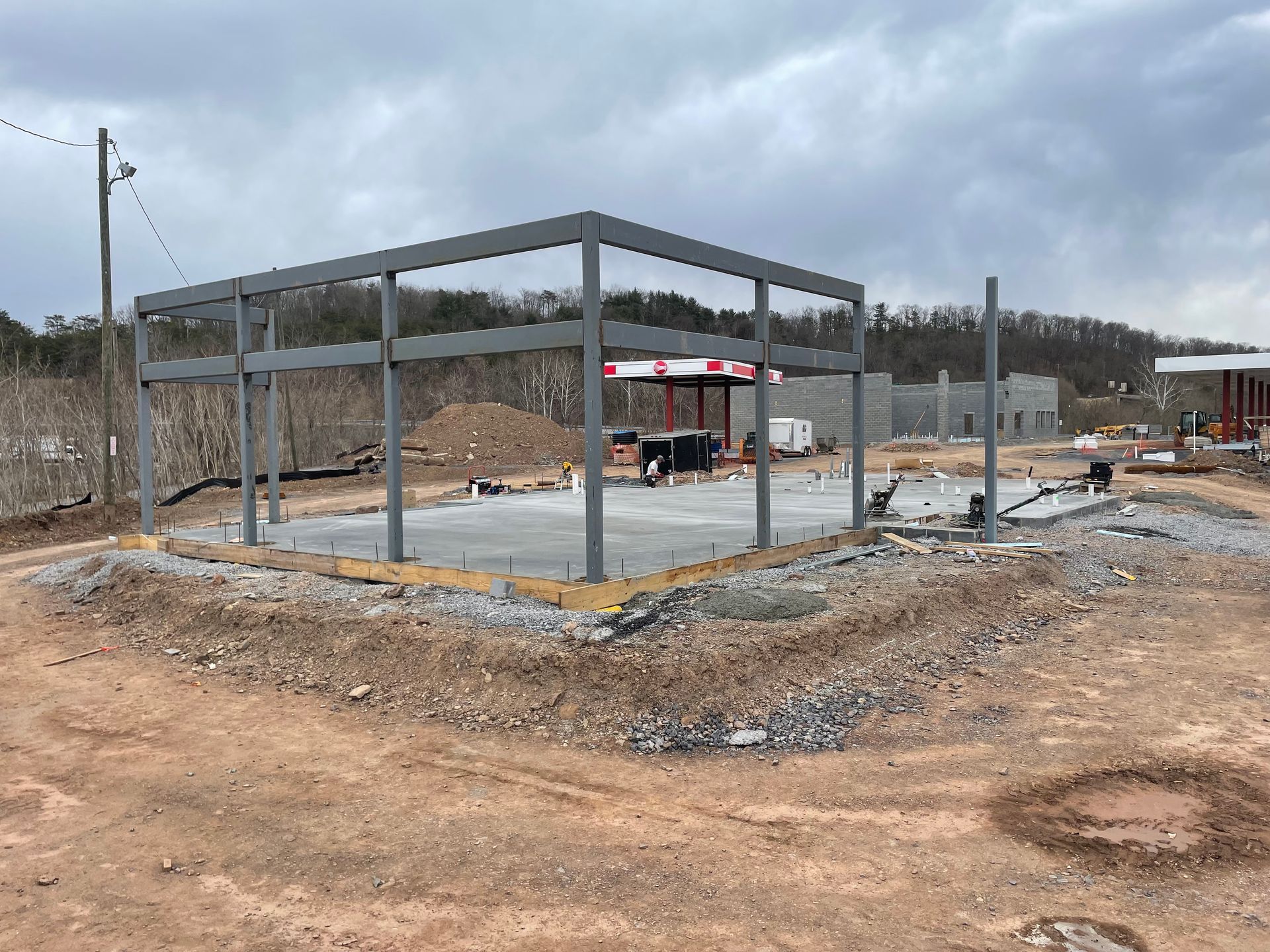 A building is being built in the middle of a dirt field.