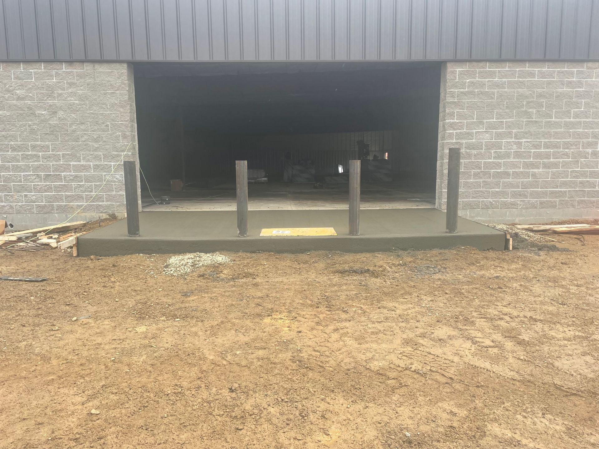 A concrete walkway is being built in front of a brick building.