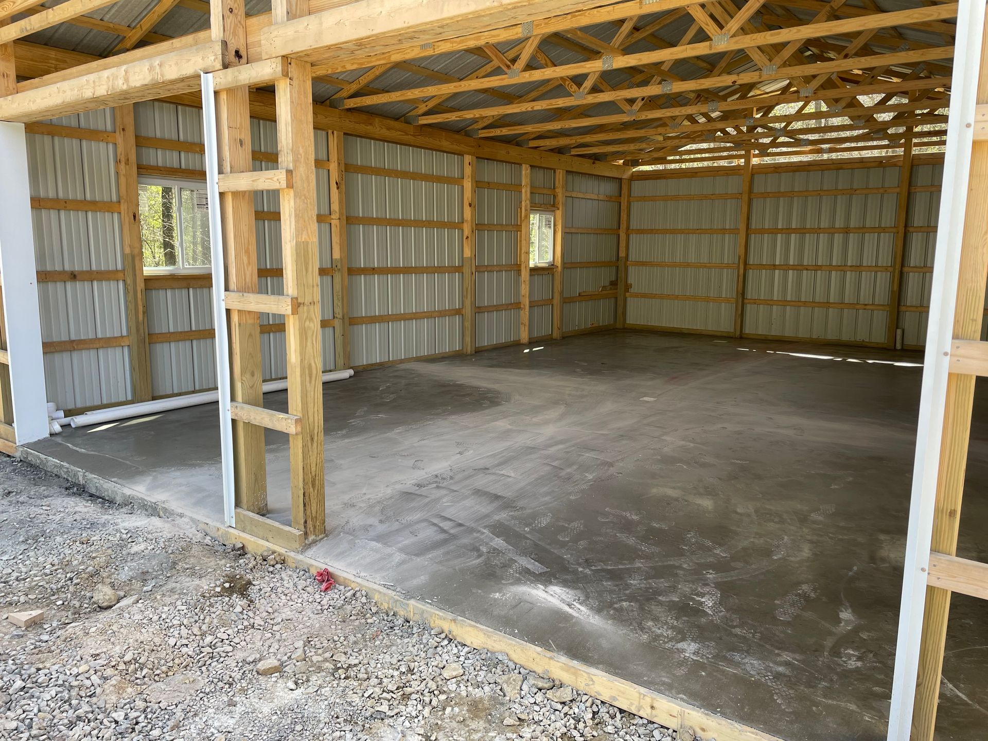 The inside of a wooden building with a concrete floor.