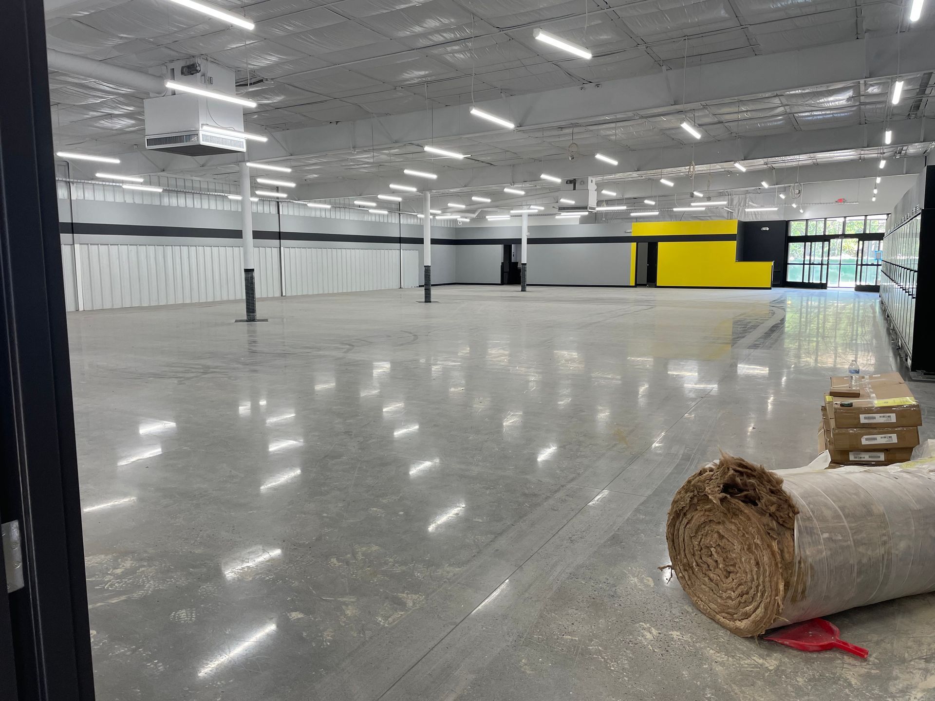 A large empty room with a roll of hay on the floor.