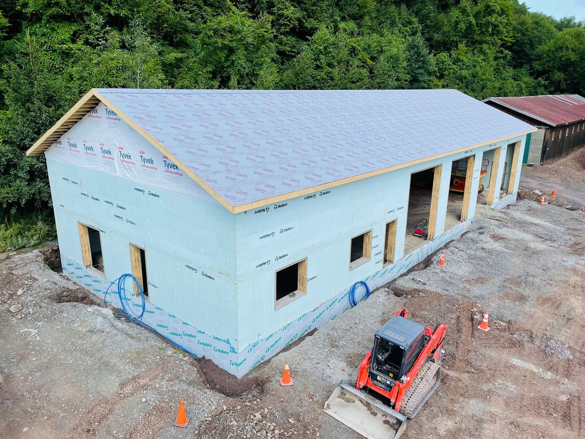 An aerial view of a building under construction with a bulldozer in front of it.
