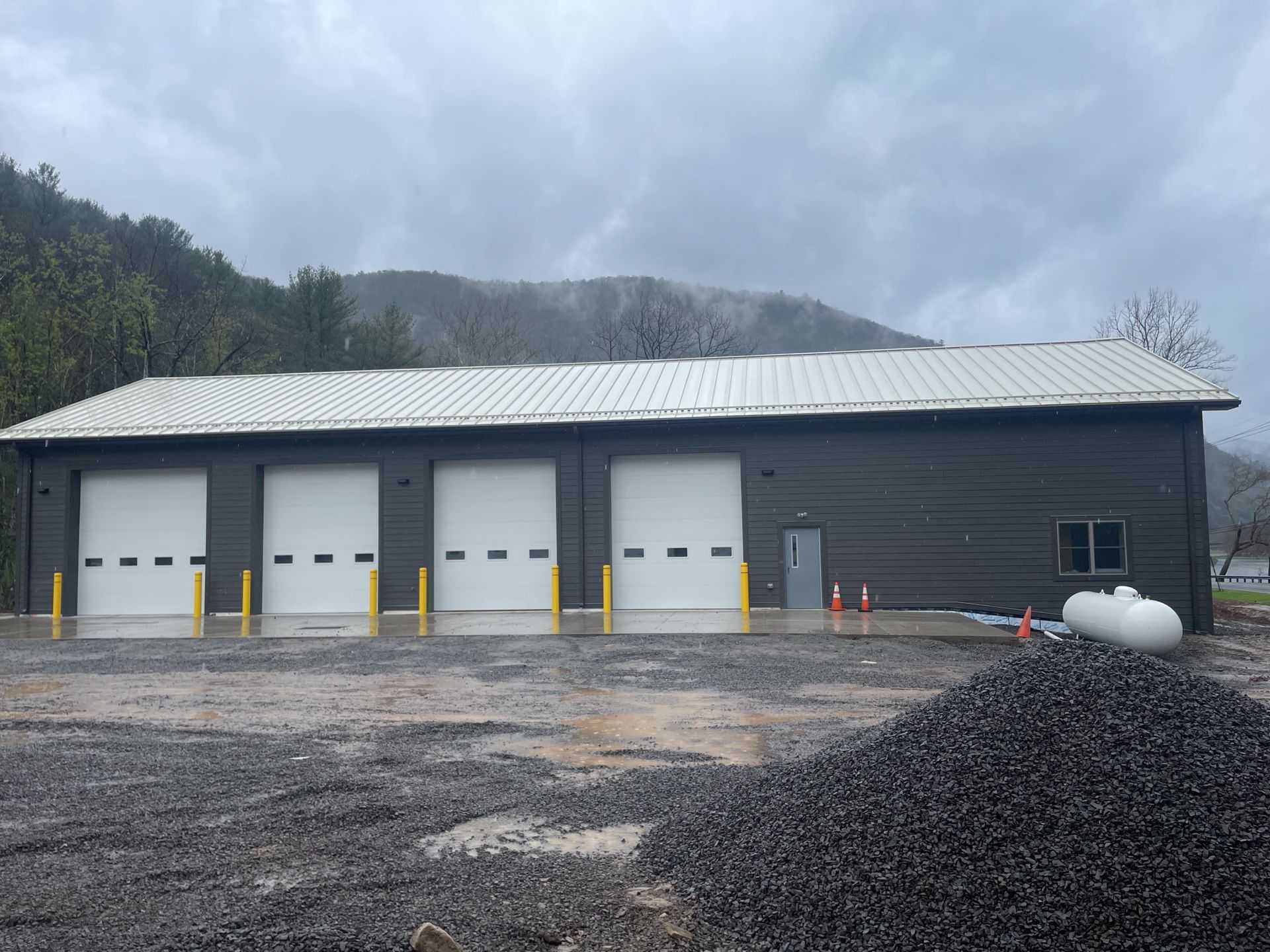 A large building with a lot of garage doors and mountains in the background