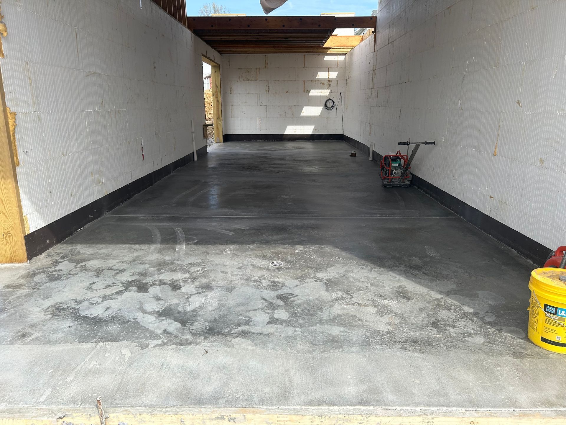 There is a yellow bucket in the middle of the garage.