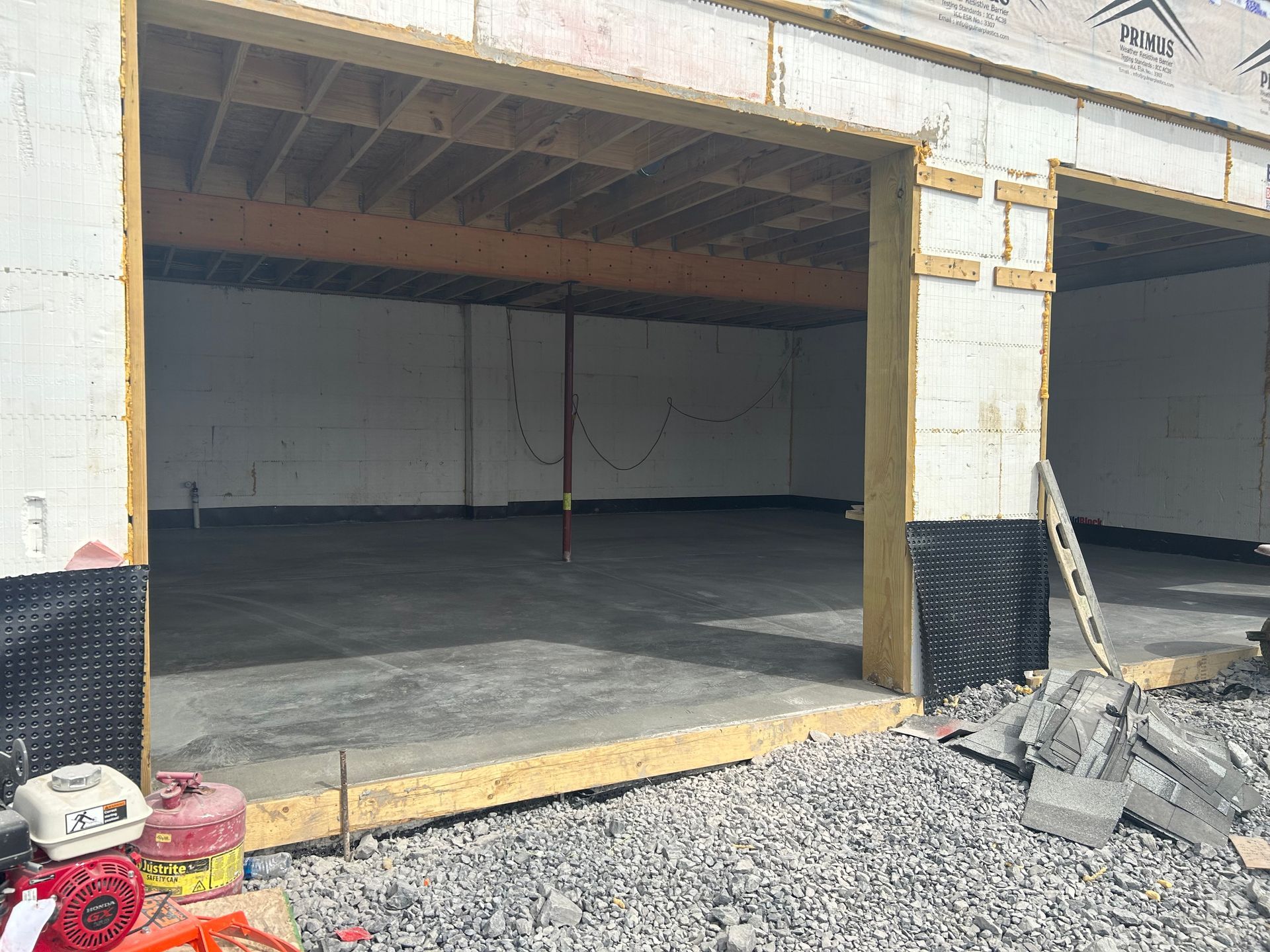 An empty garage under construction with a concrete floor.
