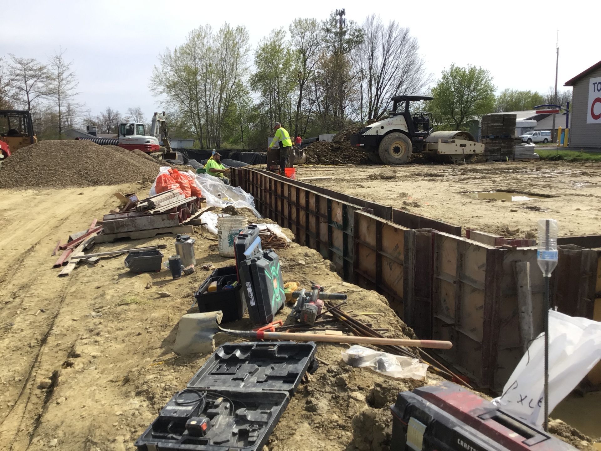 A construction site with a lot of tools in the dirt.