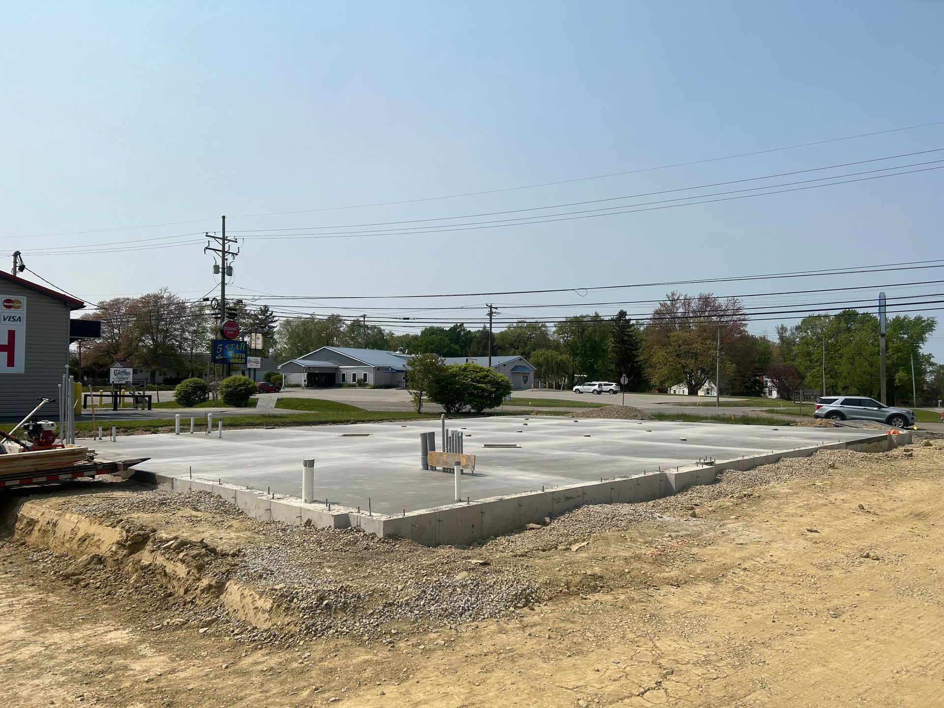 A concrete foundation is being built in a dirt field.