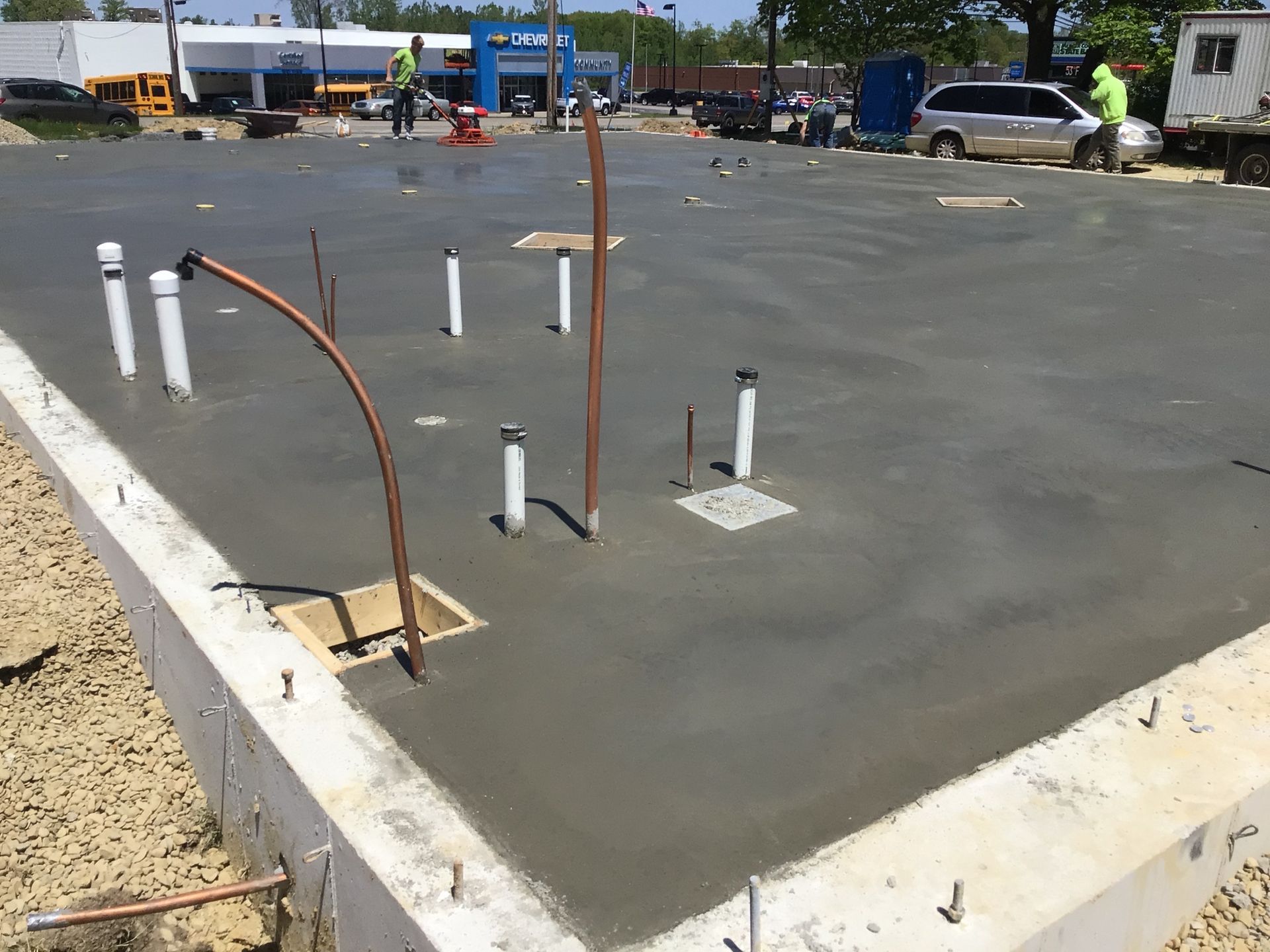 A concrete floor with pipes and wires on it