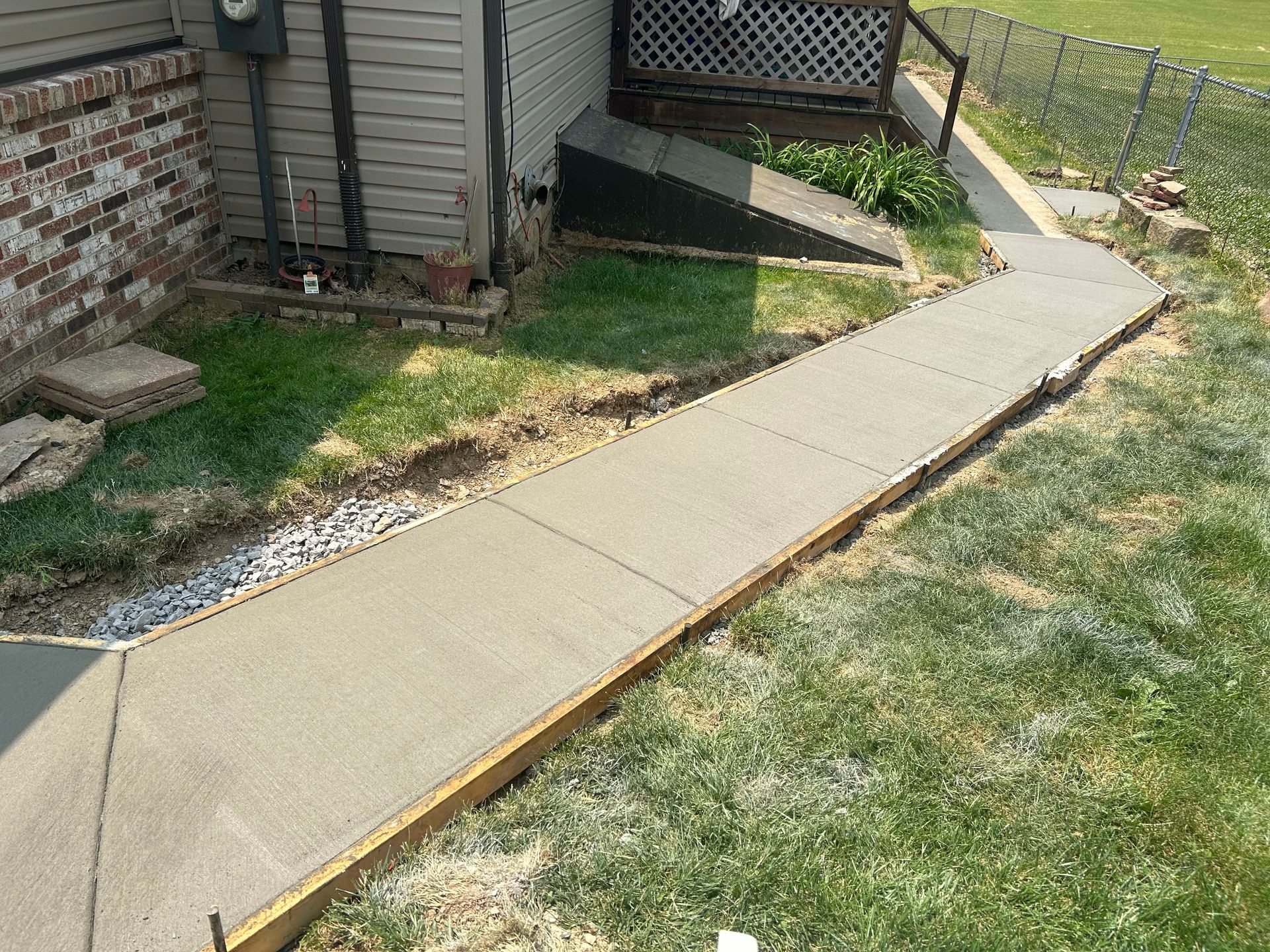 A concrete walkway is being built in front of a house.