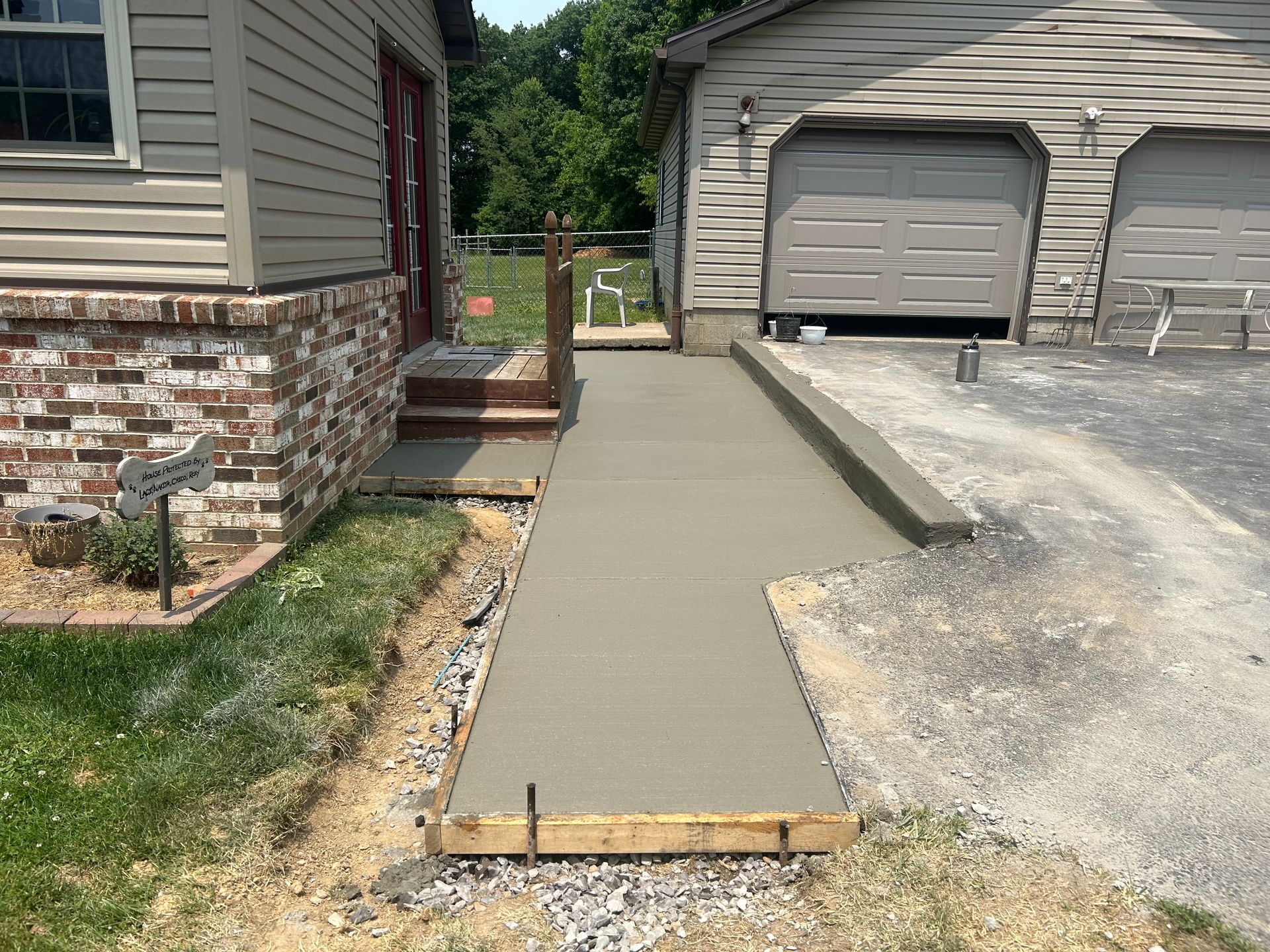 A concrete walkway is being built in front of a house