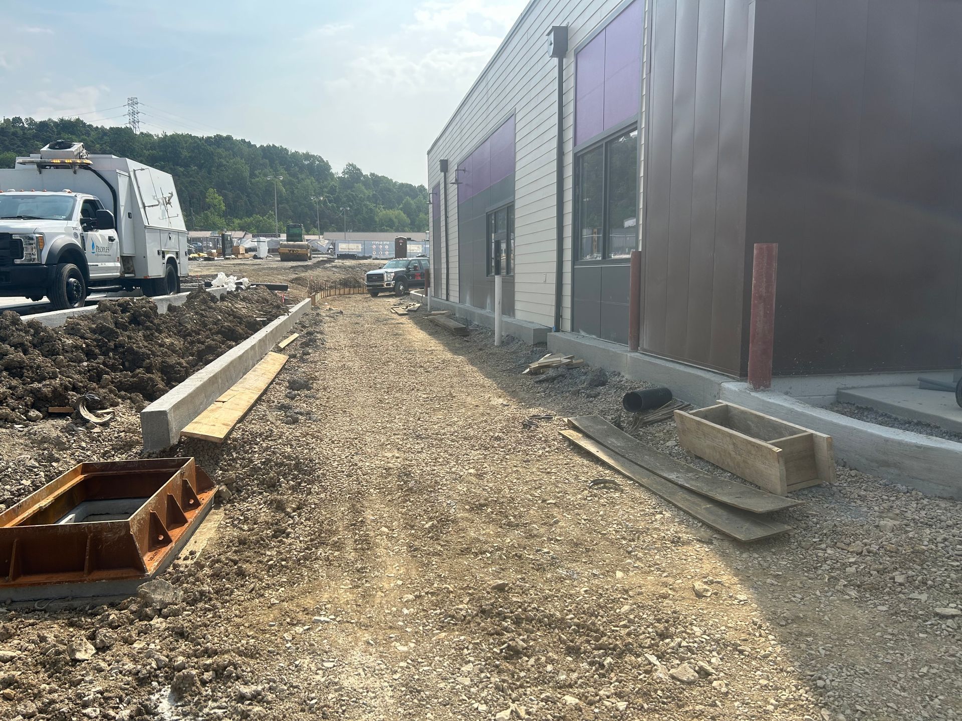 A dirt road leading to a building under construction.