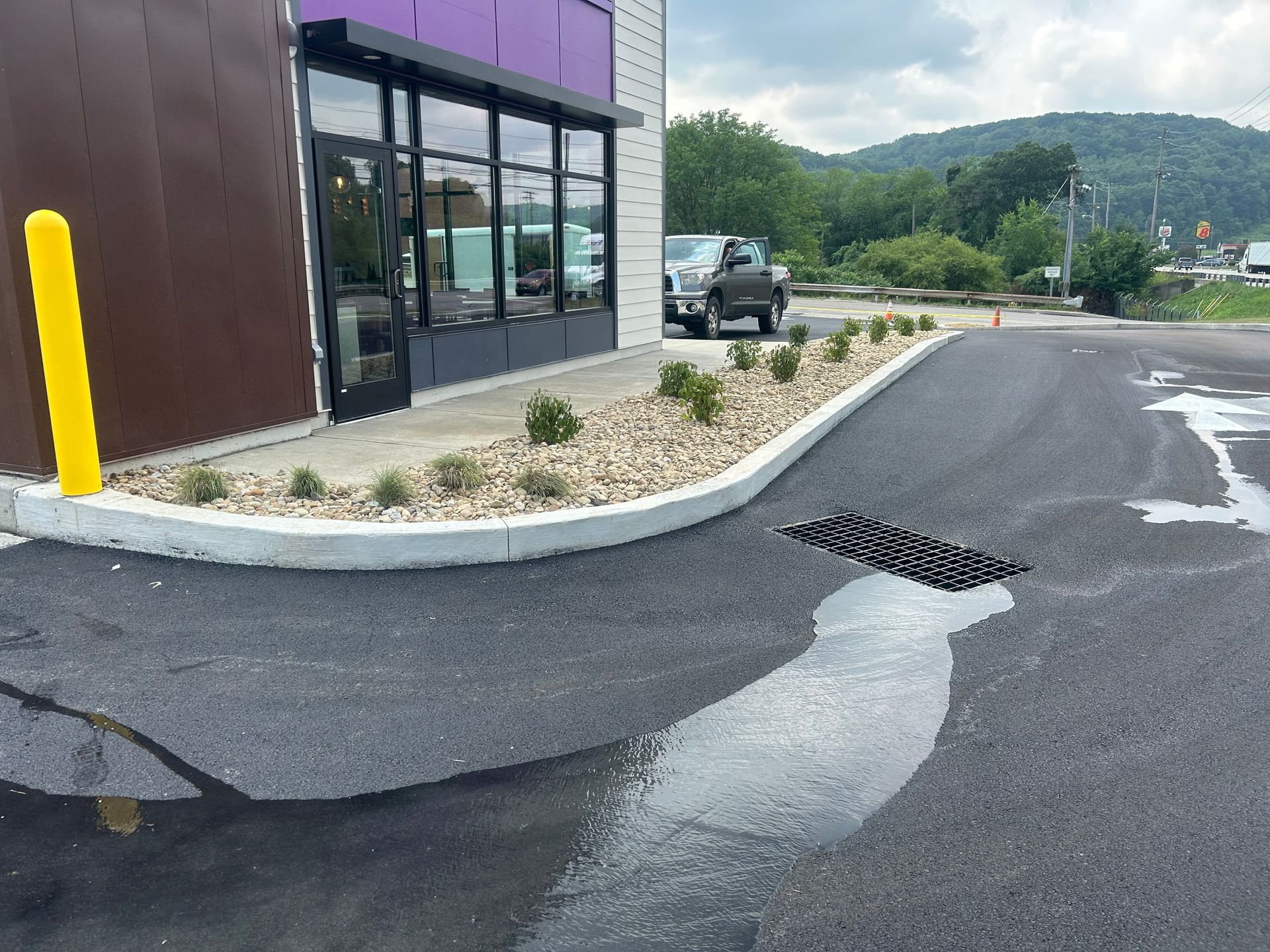 A car is parked in front of a purple building.
