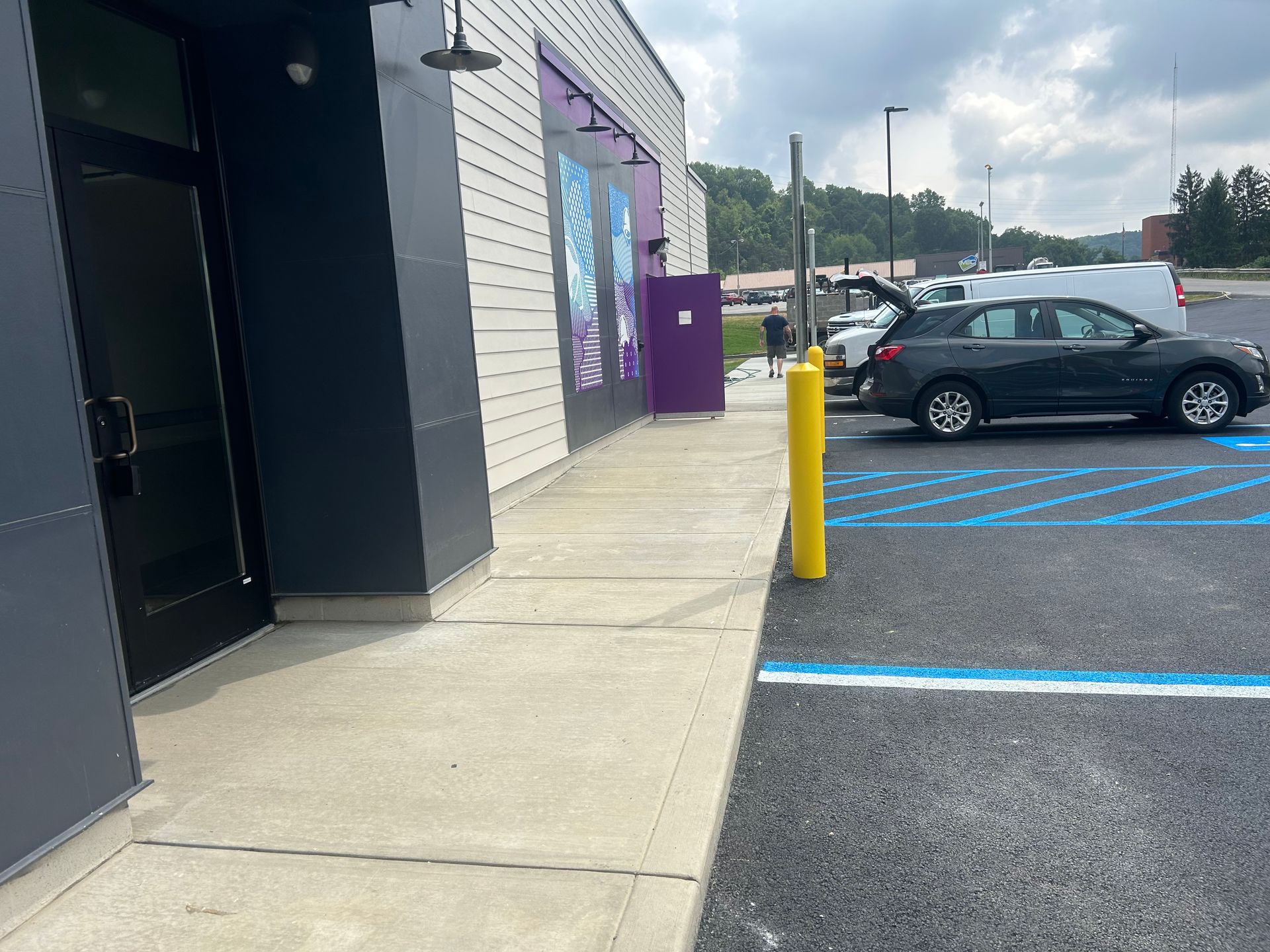 A car is parked in a handicapped parking spot in front of a building.