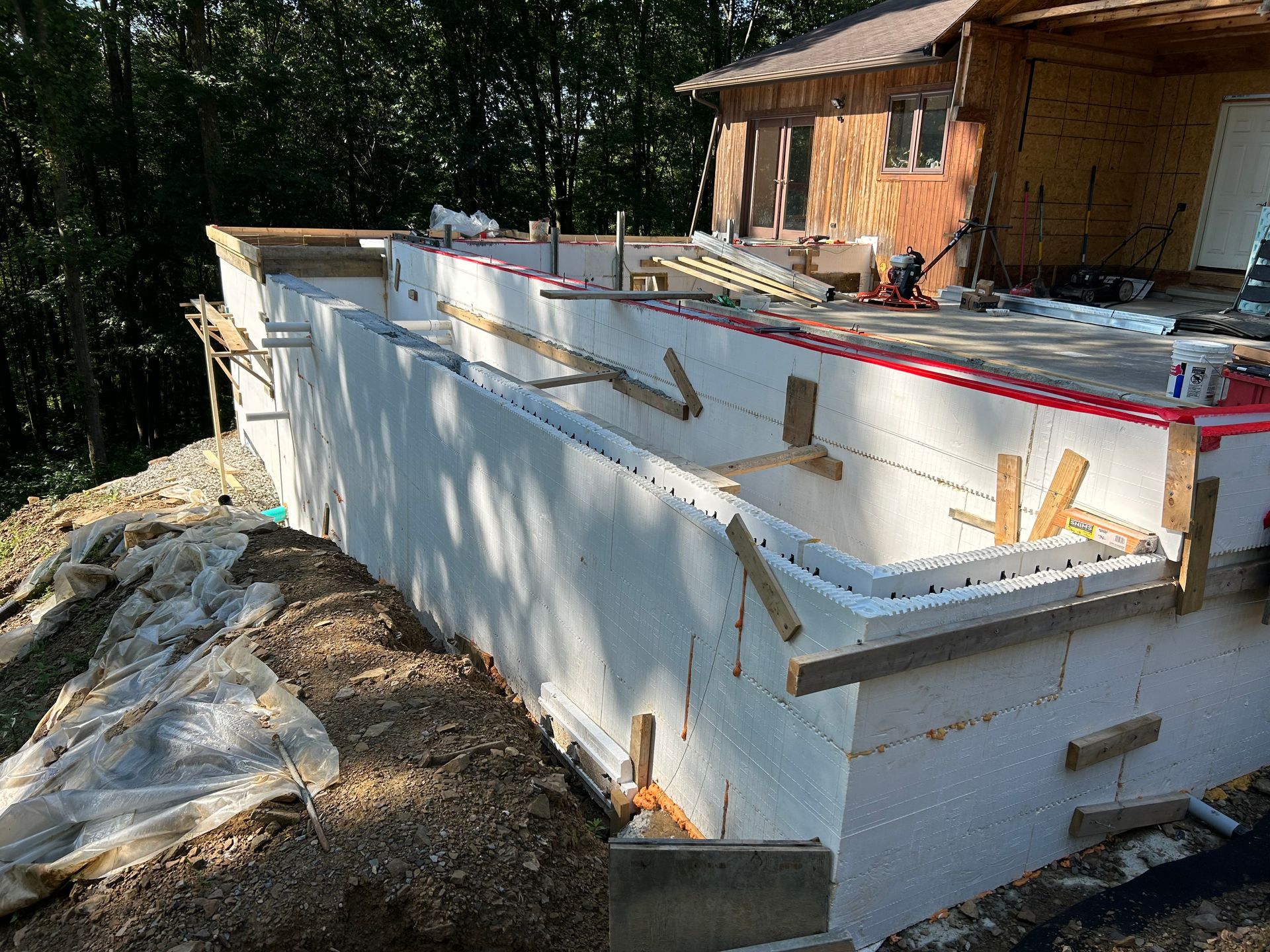 A large white wall is being built in front of a house.