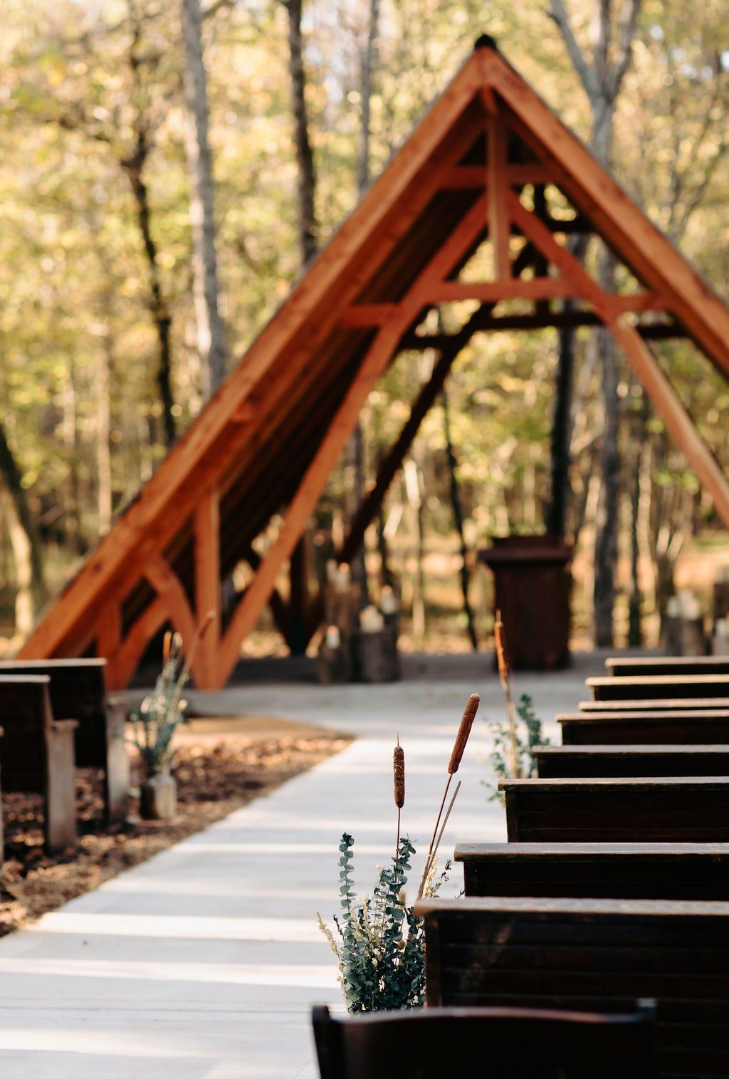 A row of wooden benches are lined up in front of a wooden structure.