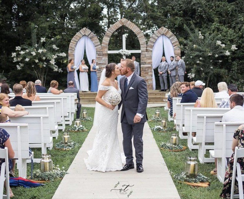 A bride and groom kissing at the end of their wedding ceremony.