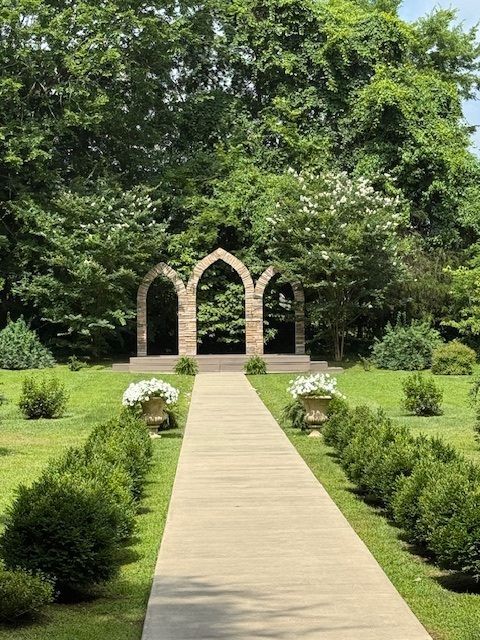 A path leading to a stone archway in a garden
