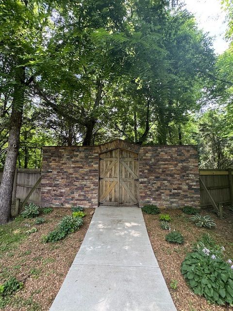 A stone wall with a wooden gate in the middle of it