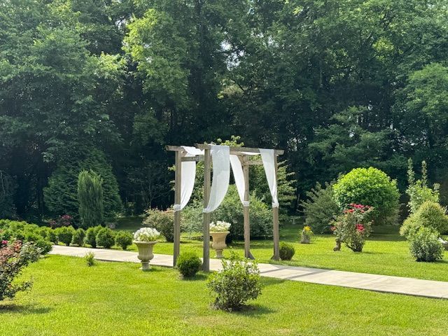 A wooden archway is sitting in the middle of a lush green field.