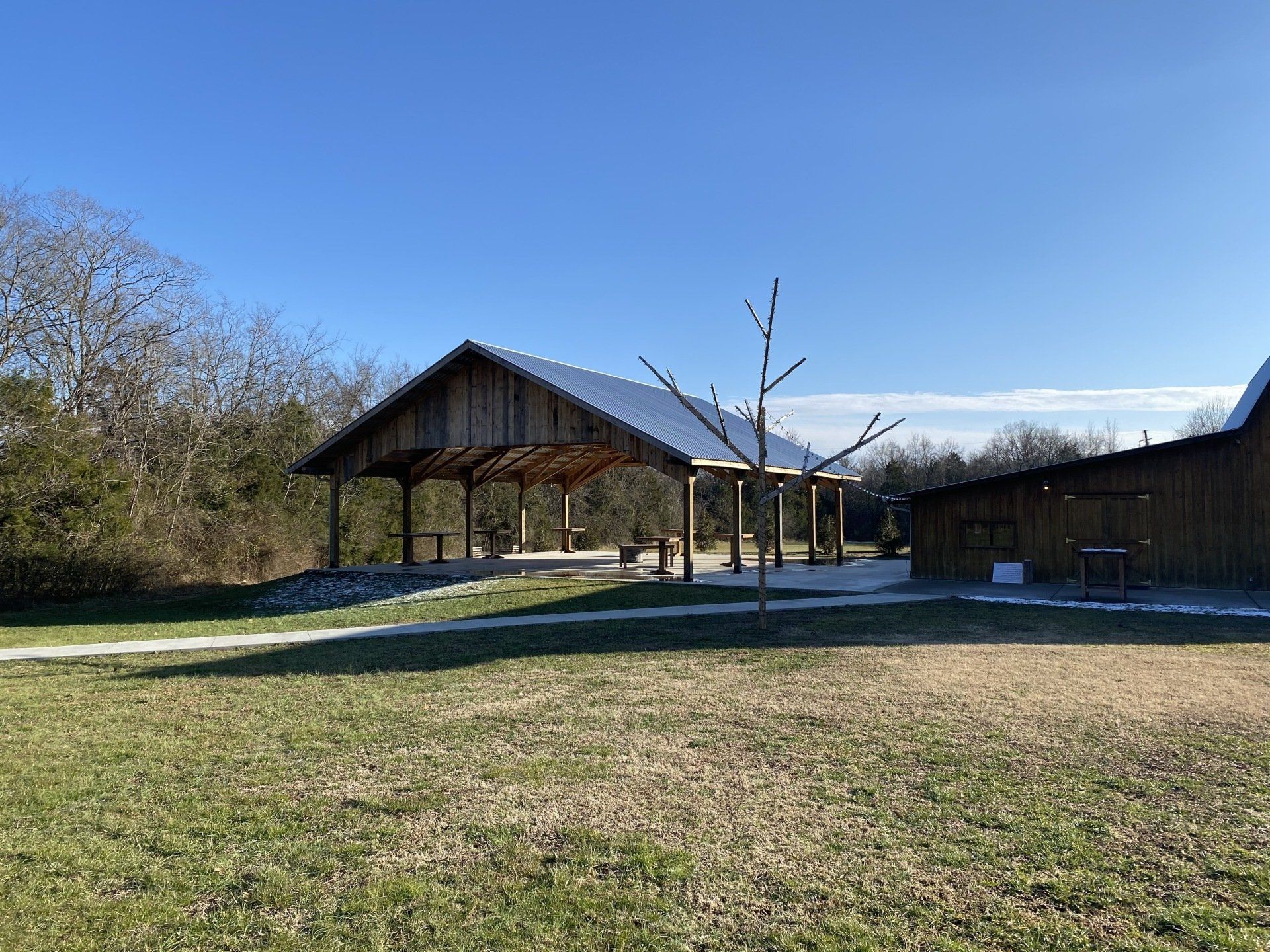 There is a pavilion in the middle of a grassy field.