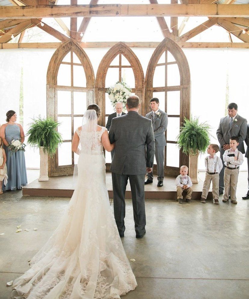 A bride and groom are standing in front of a group of people at their wedding ceremony.