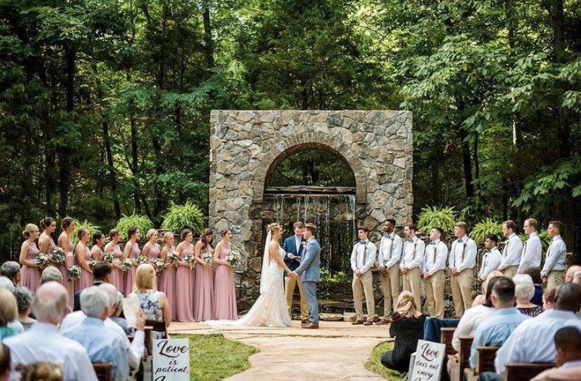 A bride and groom are getting married in front of a crowd of people.