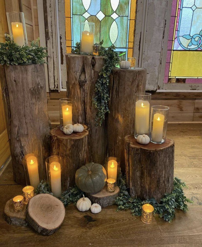 A bunch of logs with candles and pumpkins on them