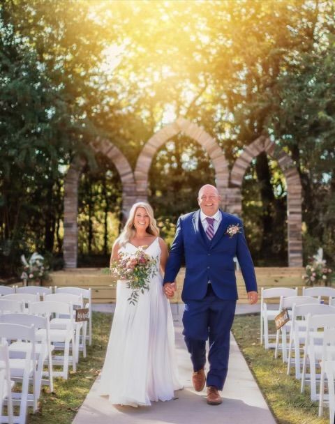 A bride and groom are walking down the aisle at their wedding