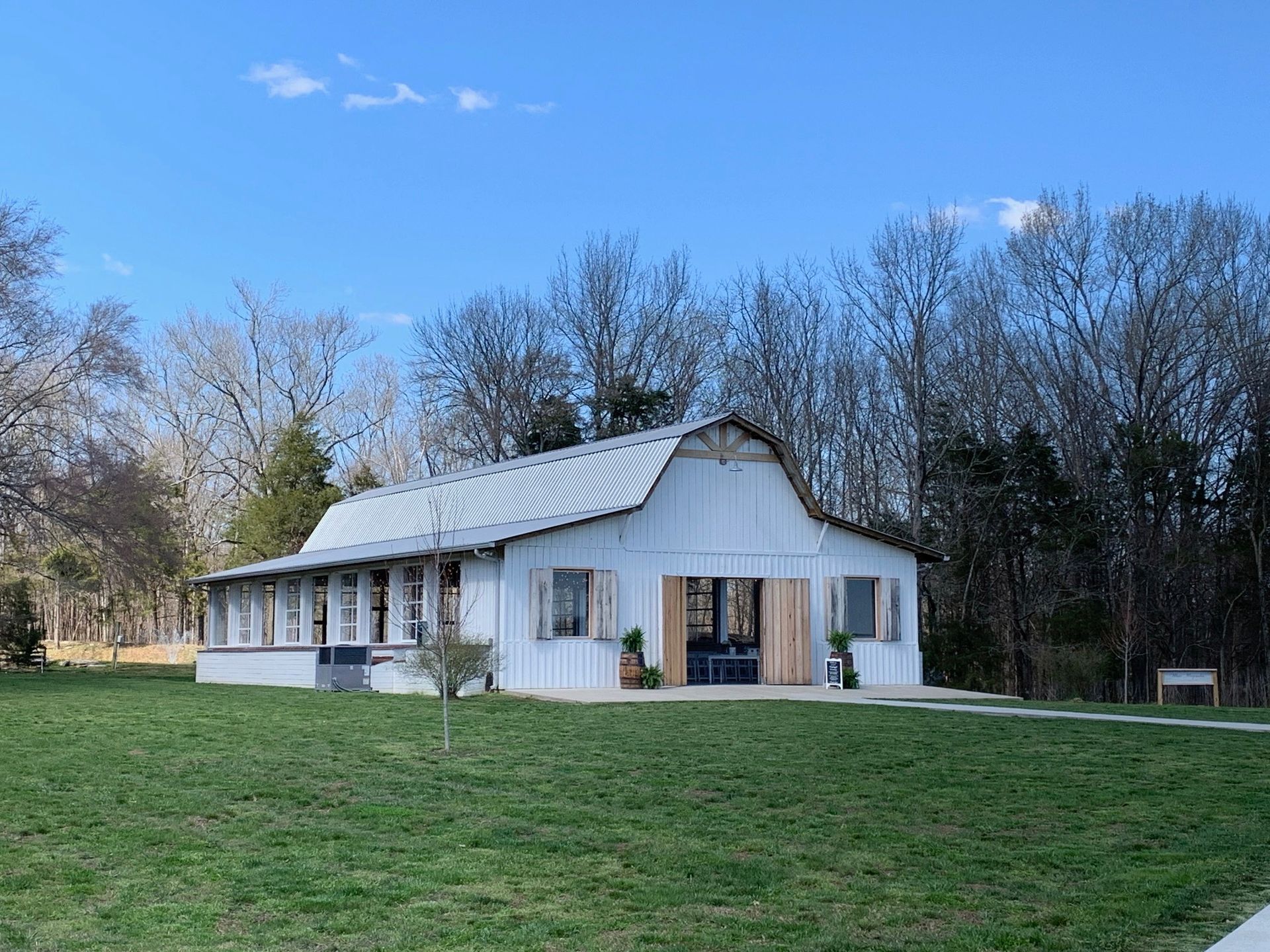 A white barn is sitting on top of a lush green field.