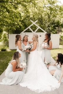 A bride and her bridesmaids are posing for a picture.