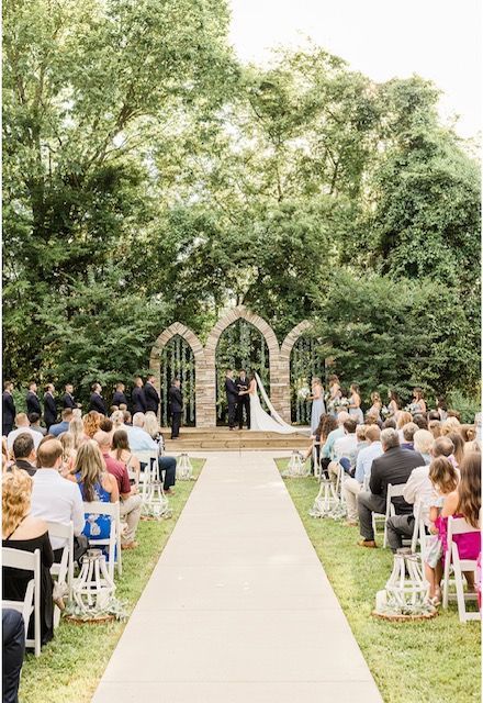 A bride and groom are getting married in front of a crowd of people at a wedding ceremony.