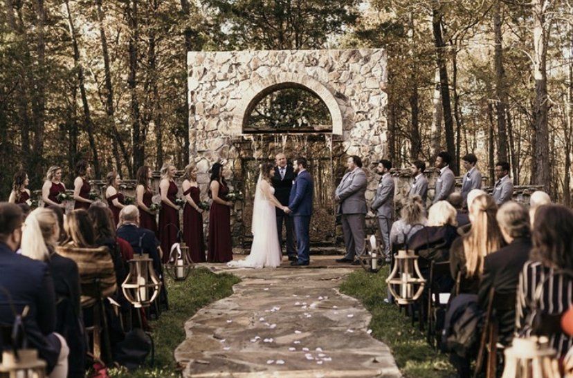 A bride and groom are getting married in front of a crowd of people at a wedding ceremony.