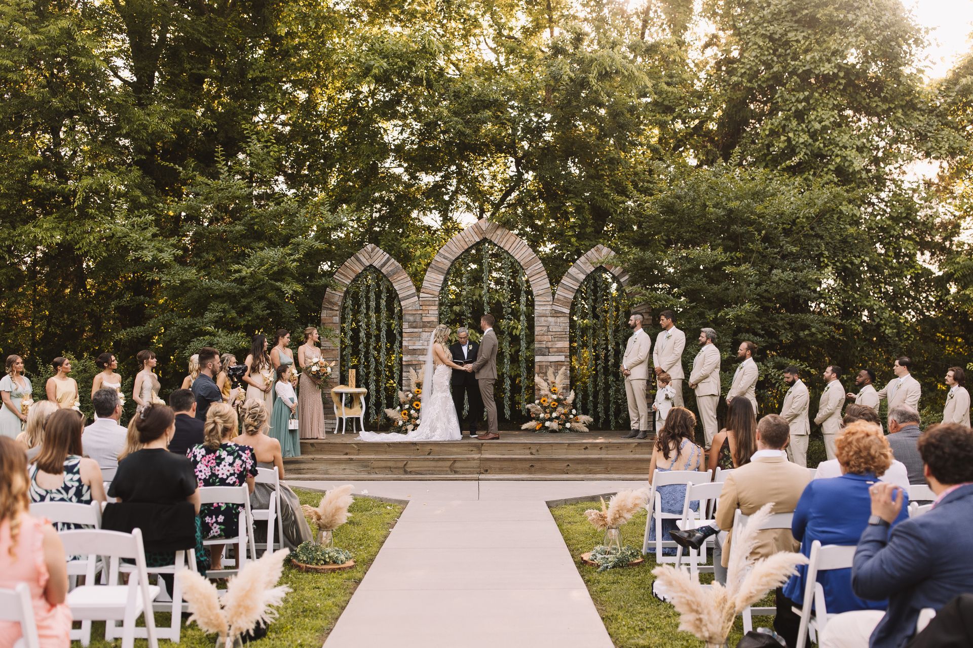 A bride and groom are getting married in front of a crowd of people at a wedding ceremony.