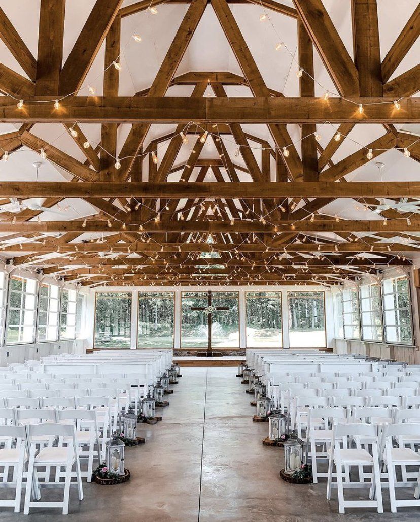 Rows of white chairs are lined up in a large room.