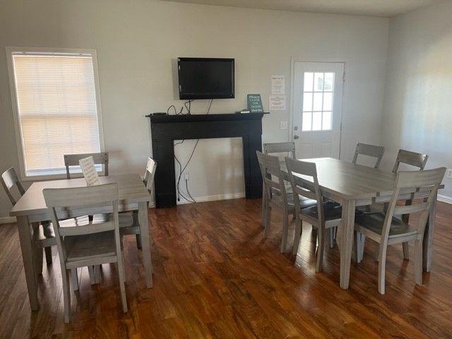 A dining room with a table and chairs and a fireplace.